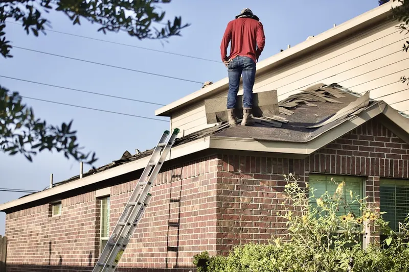 Professional roofer working on a residential roof in Goodrichville